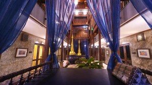 A luxurious lobby with a central staircase, blue drapes, and a chandelier. - Sunny V Hotel (Chiang Mai)
