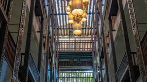A multi-level atrium with ornate railings and a central chandelier. - Sunny V Hotel (Chiang Mai)
