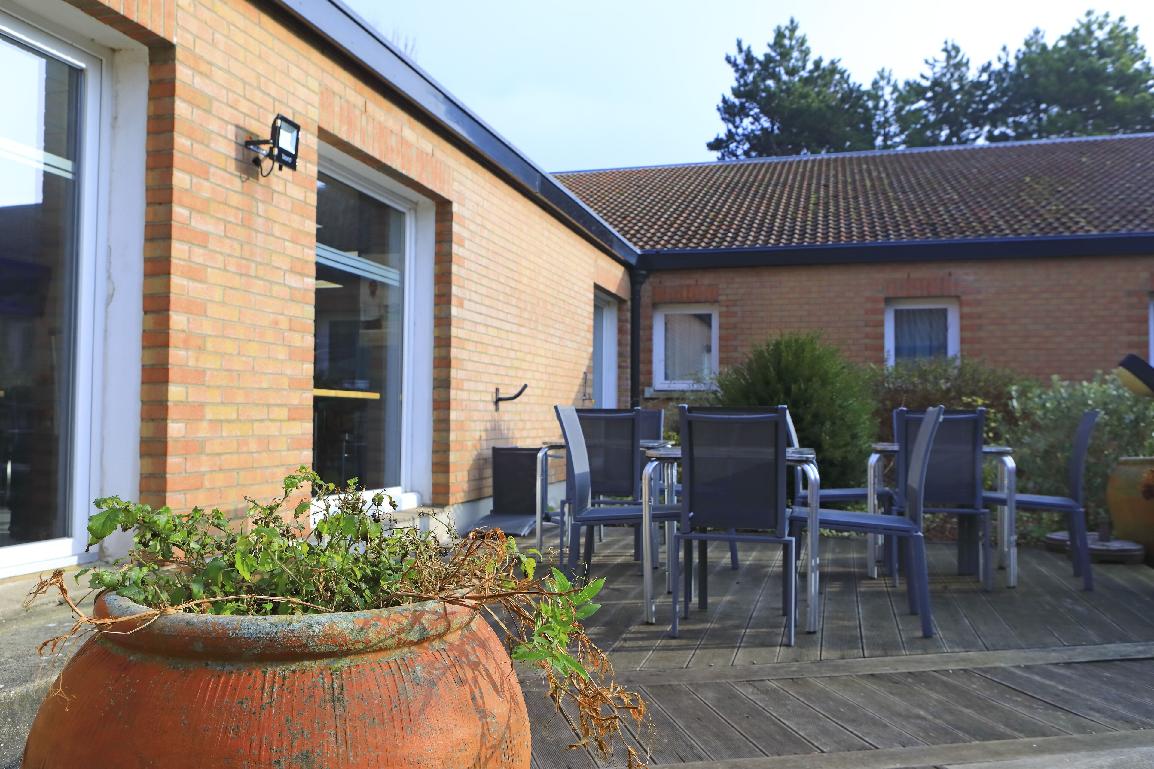 A patio area with outdoor seating and a large planter.
