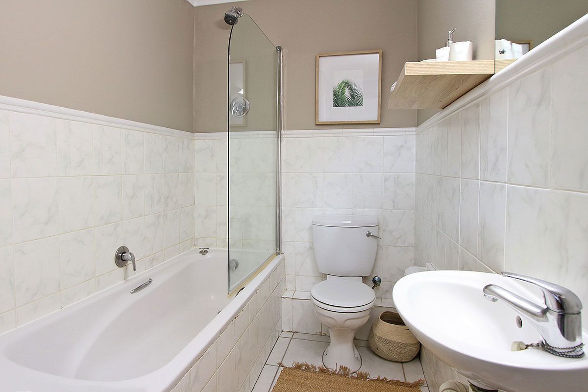 A bathroom with a bathtub, toilet, and sink.