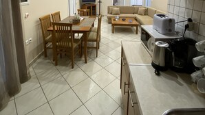 A compact living space with a dining area, kitchenette, and a sofa. - Villa Angela (Corfu)