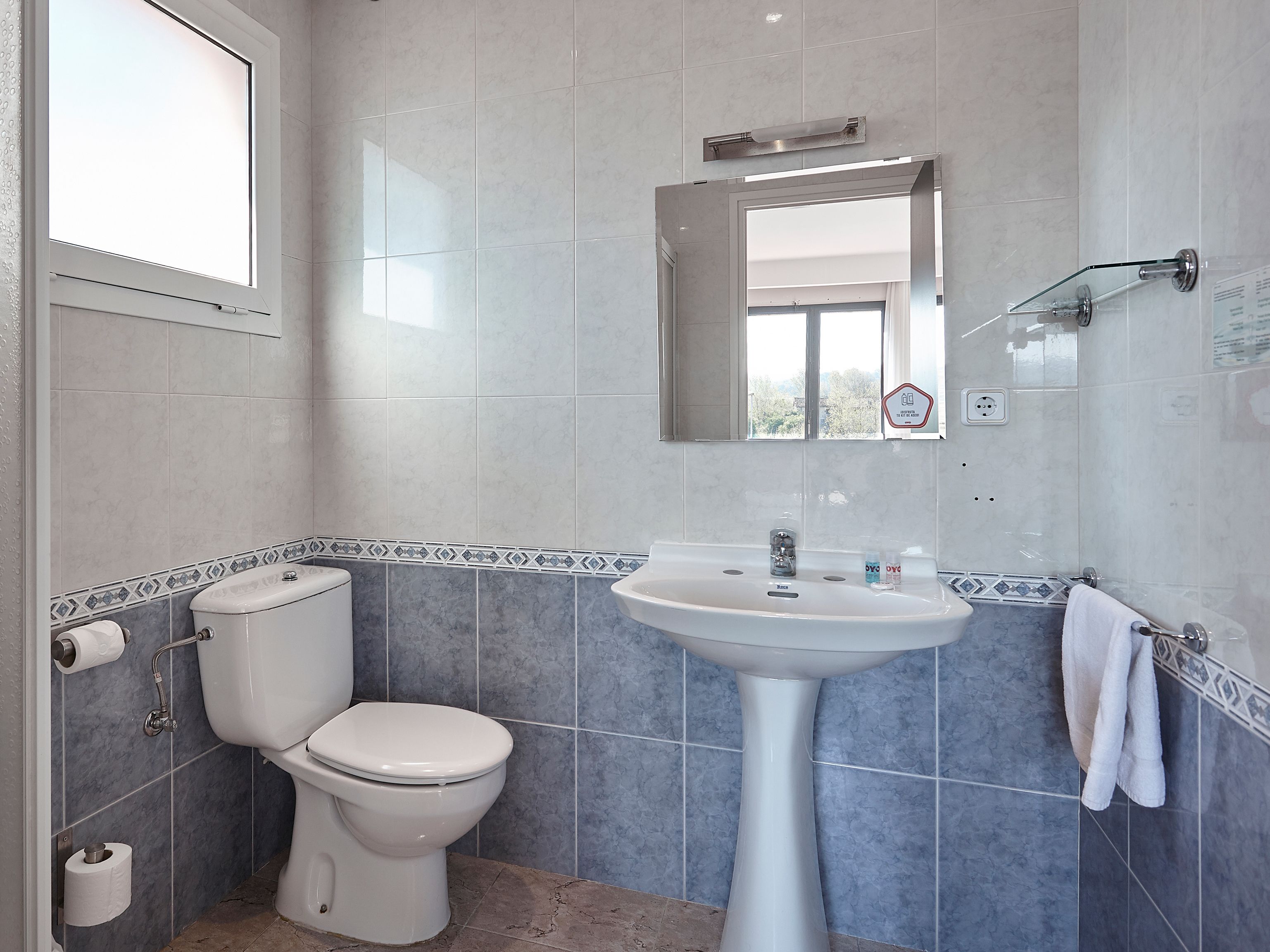 Un baño con inodoro, lavabo y espejo.