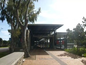 A covered pedestrian walkway leading to a stadium entrance with a sign reading "Stadium Station".