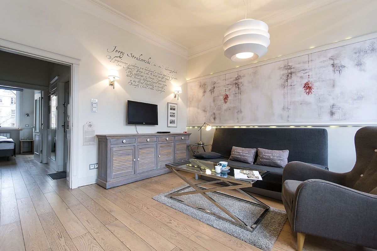 Una sala de estar moderna con un sofá, sillones, una mesa de centro y un televisor.