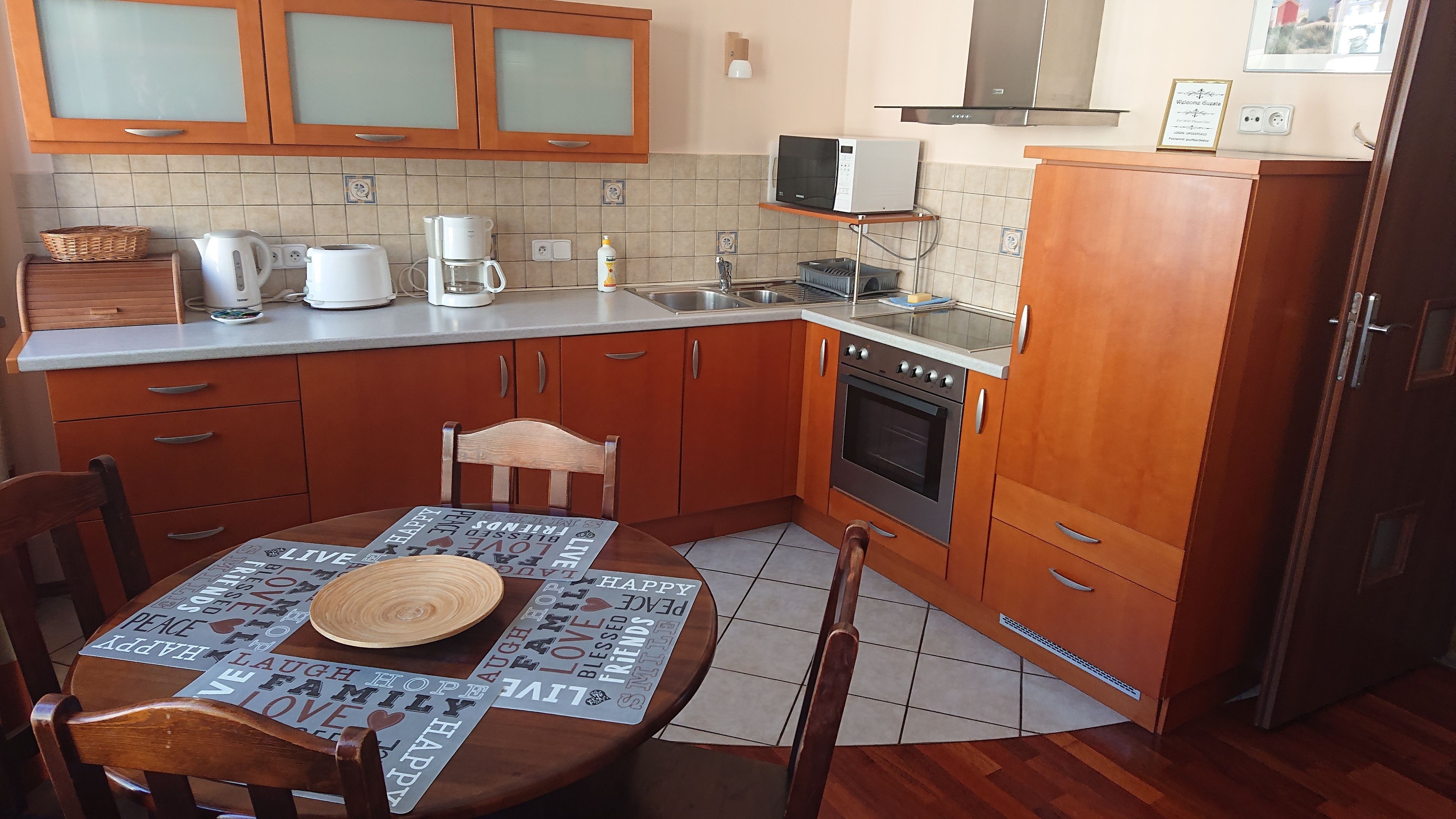 A kitchen with wooden cabinets, a microwave, a coffee maker, and a table with a placemat.