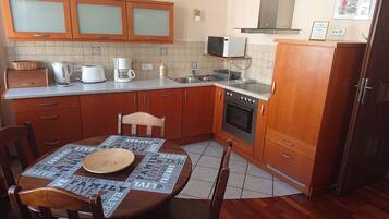 A kitchen with wooden cabinets, a microwave, a coffee maker, and a table with a placemat.