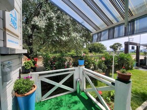 A rooftop garden with potted plants and a green artificial turf area.