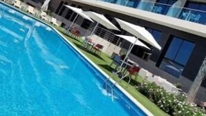 A modern hotel with a pool, multiple balconies, and outdoor seating areas. - Az Hotel Le Zephyr Mostaganem (Mazagran)