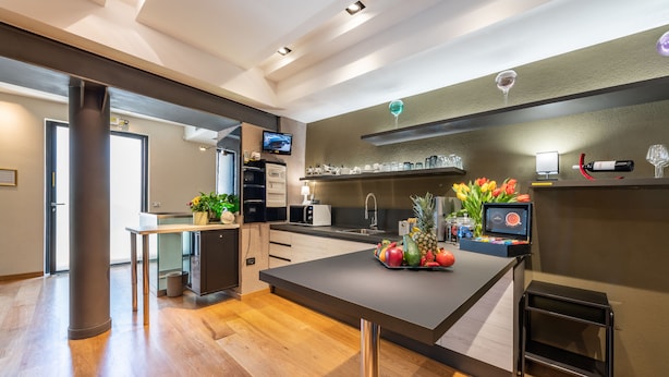 Una cocina moderna con una isla central, electrodomésticos integrados y un pequeño comedor.