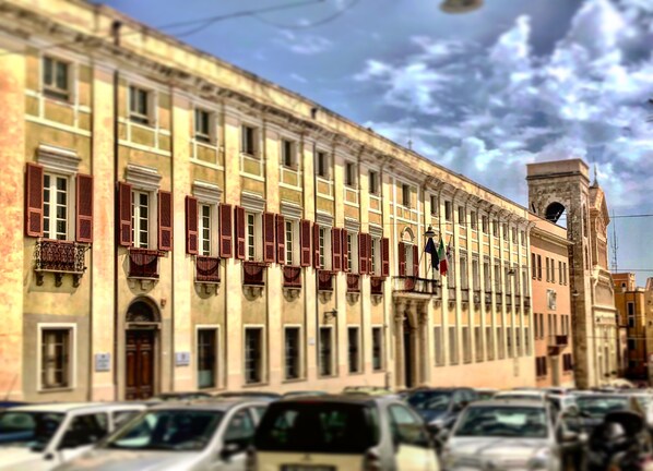 A row of historic buildings with uniform architecture, featuring arched windows and shutters.