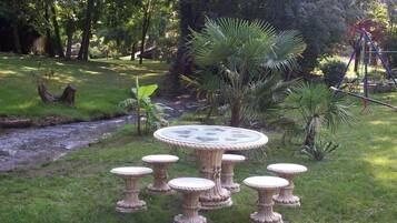 A round table with six matching stools in a garden setting.