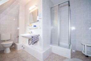 A modern bathroom with a toilet, sink, and shower. - Villa Unger (Altenberg)