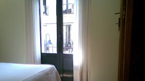 Une pièce comprenant un lit, une porte donnant sur un espace extérieur et une vue sur l’extérieur.