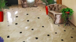 Um lobby amplo com um grande lustre, um sofá e plantas em vasos.