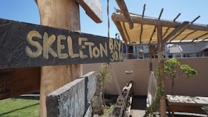Un letrero de madera que dice "SKELETON BAY".