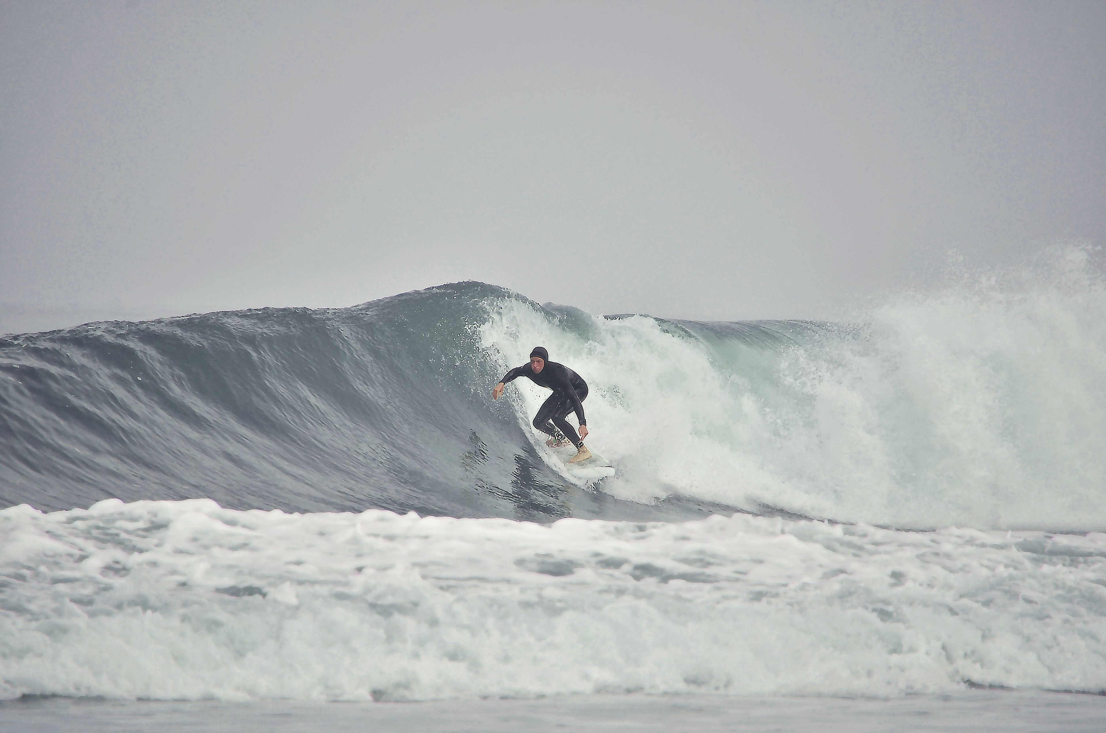 Um surfista deslizando numa onda grande.