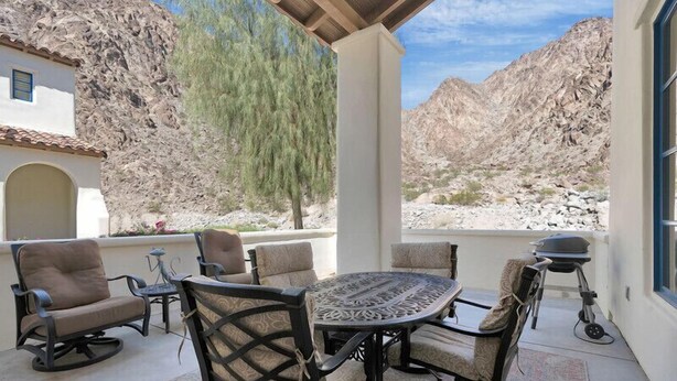 An outdoor patio with a round table and chairs, a grill, and a view of rocky mountains. - Sensational Single Story Townhome Against the Mountains w/ garage, LQ121 (La Quinta)