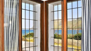 A corner window with a view of the sea and hills. - Villa XOROI- Dream front line Villa in Betlem (Mallorca) with pool and direct access to the sea. - Free Wifi (Artá)