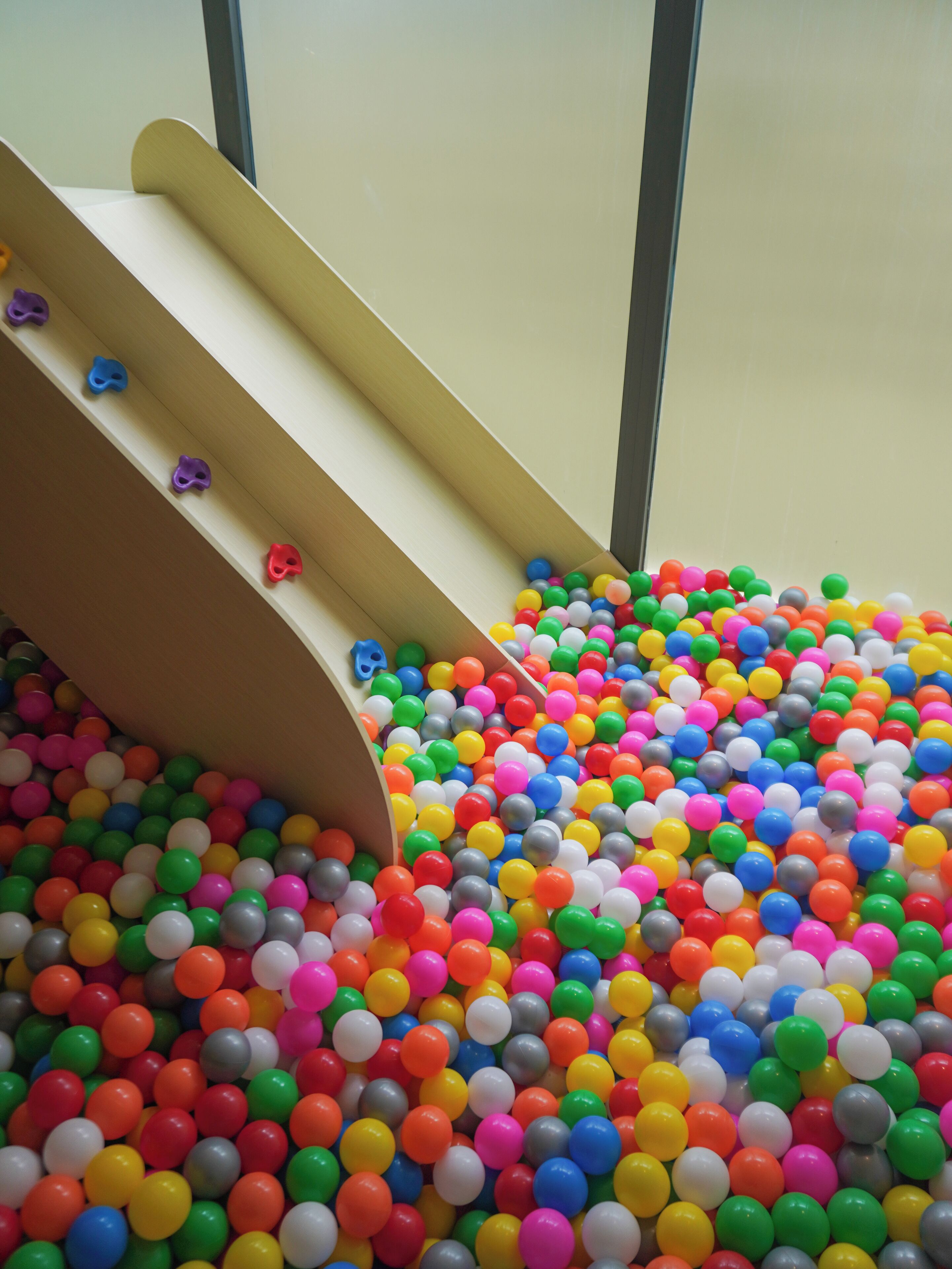 A colorful ball pit with a slide.