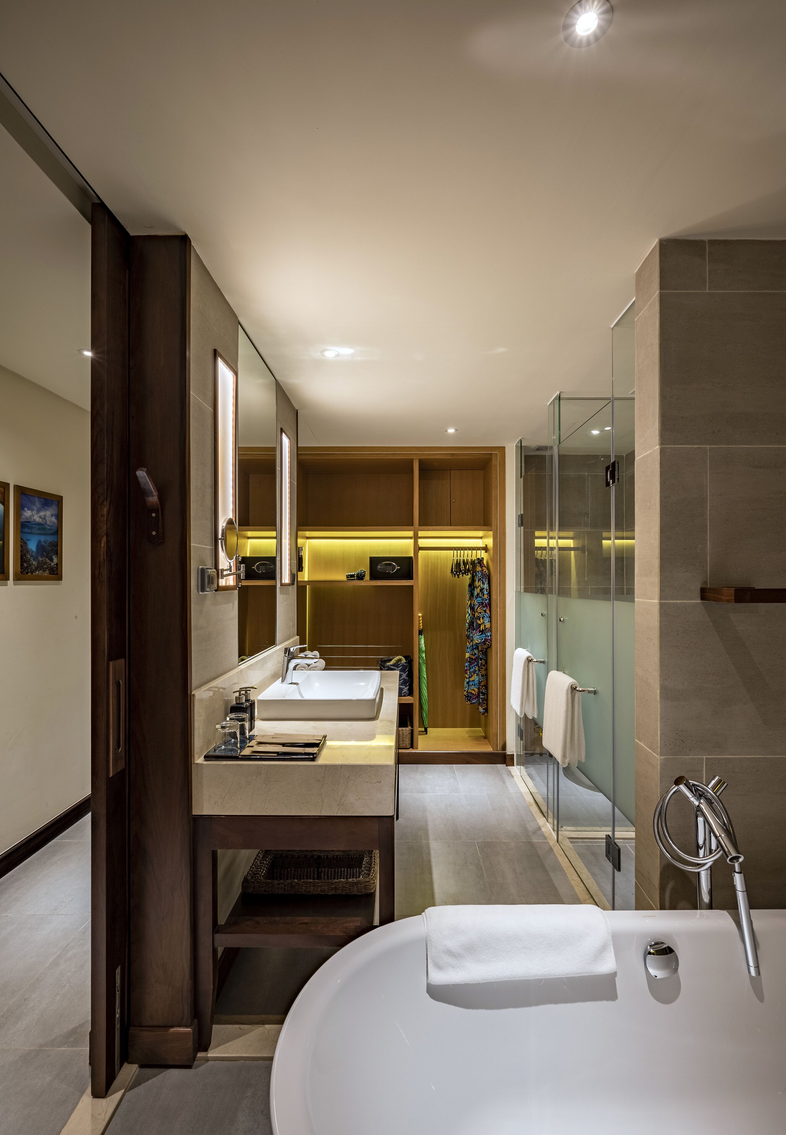 A modern bathroom with a large bathtub, two sinks, and a walk-in shower.