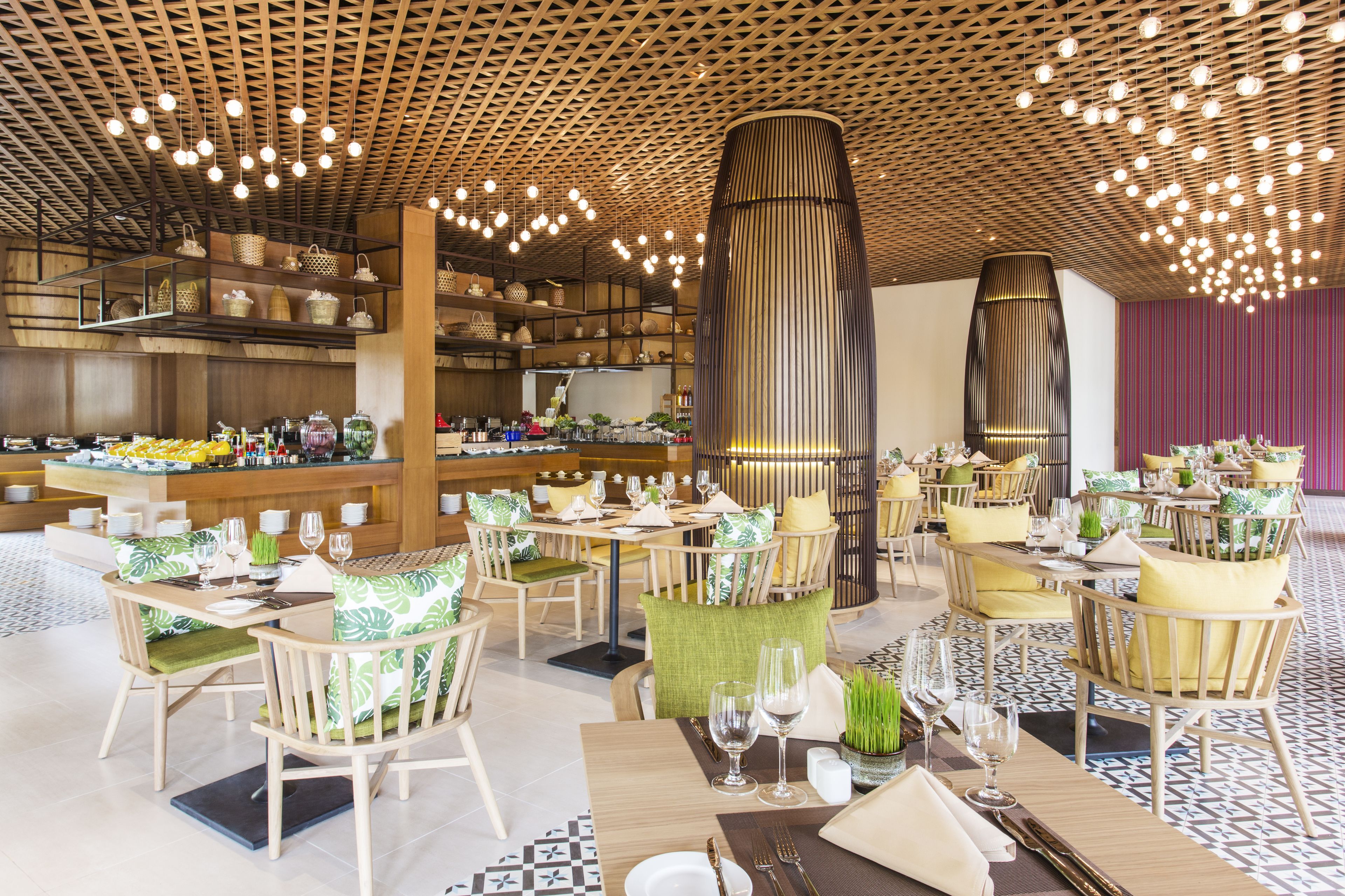 A modern restaurant with wooden furniture, a central column, and hanging lights.