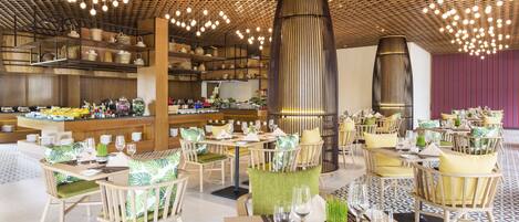 A modern restaurant with wooden furniture, a central column, and hanging lights.