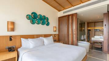 Une chambre d’hôtel avec un grand lit, une tête de lit en bois, un téléphone fixé au mur et une salle de bain équipée d’une baignoire et d’un lavabo.