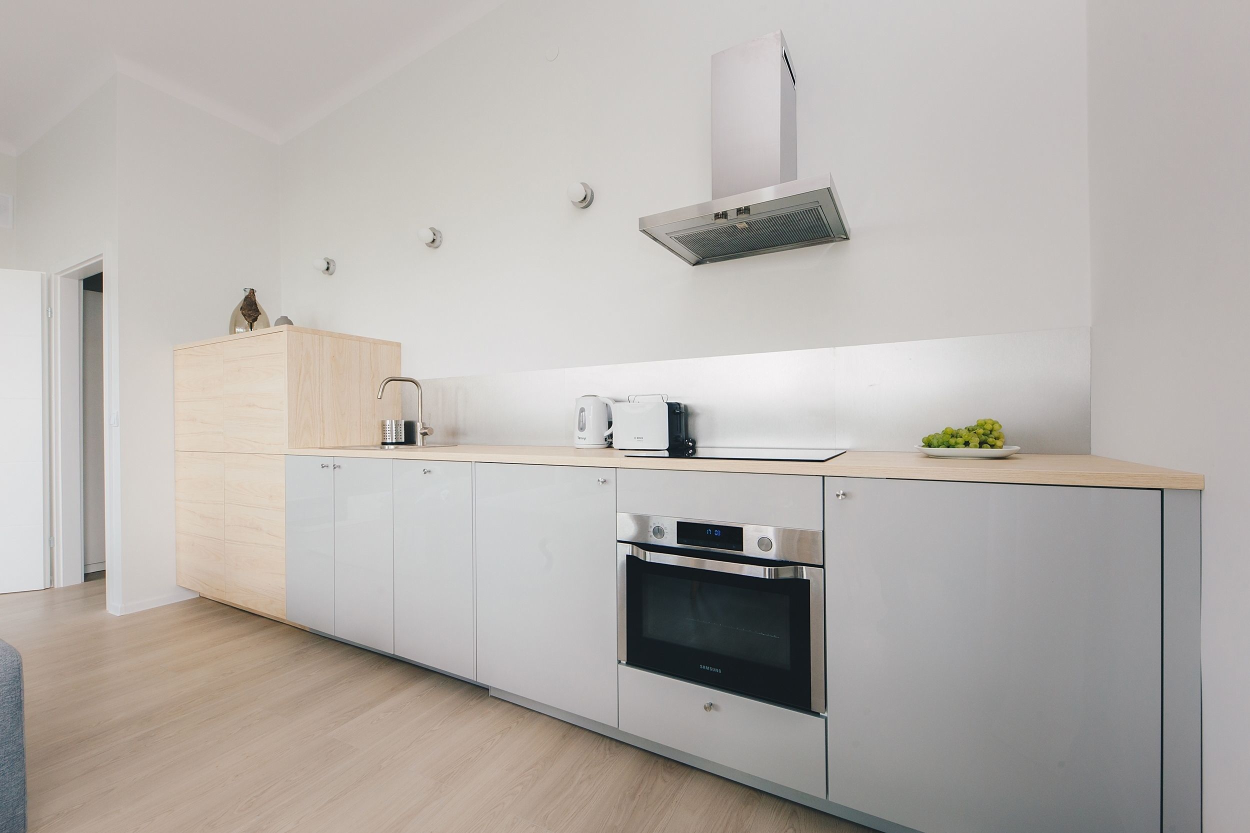 Uma cozinha moderna com forno embutido, micro-ondas e torradeira.