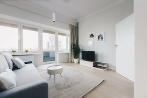 Apartamento premium, 1 cama Queen e sofá-cama, vista para a cidade | Sala de estar | TV de tela plana