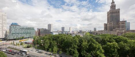 A cityscape with a prominent historical building, modern high-rises, and a green park area.