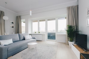 Apartamento premium, 1 cama Queen e sofá-cama, vista para a cidade | Área de estar | TV de tela plana