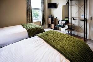 A hotel room with two beds, a TV, a desk, and a wardrobe. - The Royal Station Hotel (Carnforth)