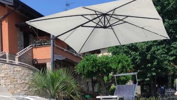 Piscina límpida com espreguiçadeiras e um guarda-sol.