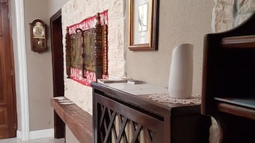 Una zona de recepción con un mostrador de madera, un reloj y obras de arte enmarcadas en la pared.