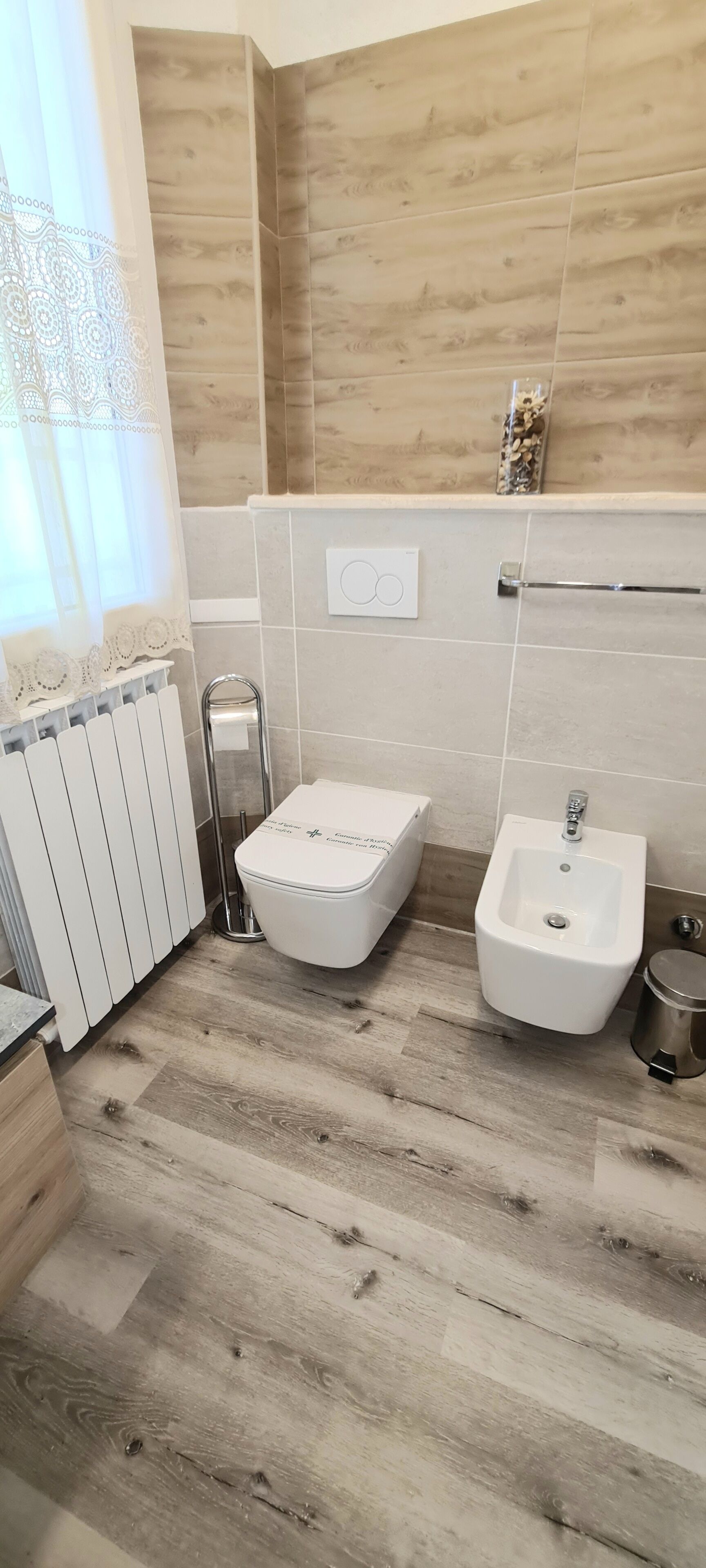 Une salle de bain moderne équipée de toilettes, d’un bidet et d’un radiateur.
