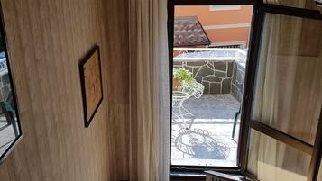 A staircase with a view of an outdoor patio area, a framed picture on the wall, and a window with curtains.