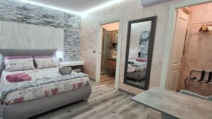Quarto moderno com uma cama grande, mesas de cabeceira, um espelho e piso de madeira.