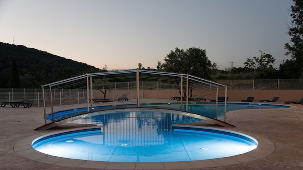 A swimming pool with a covered area and lounge chairs. - Camping Le Sous Bois (Saint-Maurice-d'Ibie)