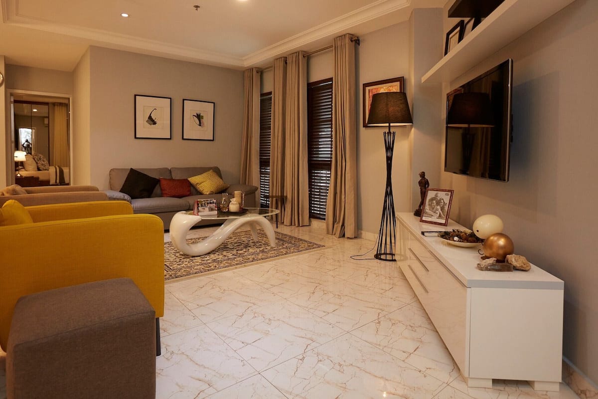 Un salon moderne comprenant un canapé, des fauteuils, une table basse et un téléviseur.