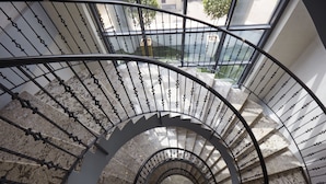 A spiral staircase with metal railings and stone steps. - Belanova Apartments & Suites (Abuja)