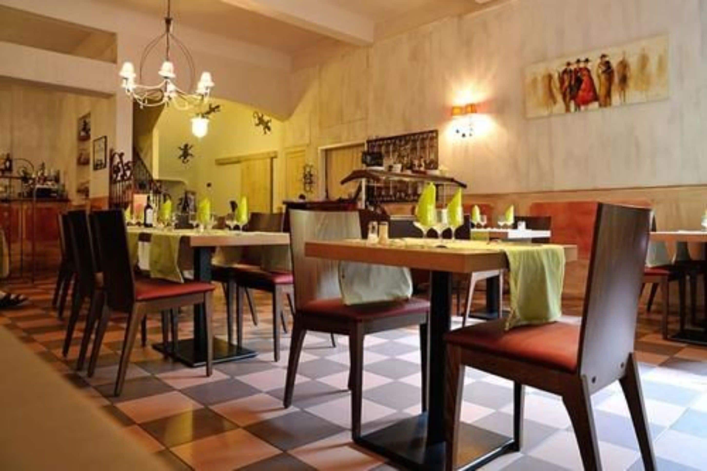 A restaurant with checkered flooring, wooden tables, and chairs.