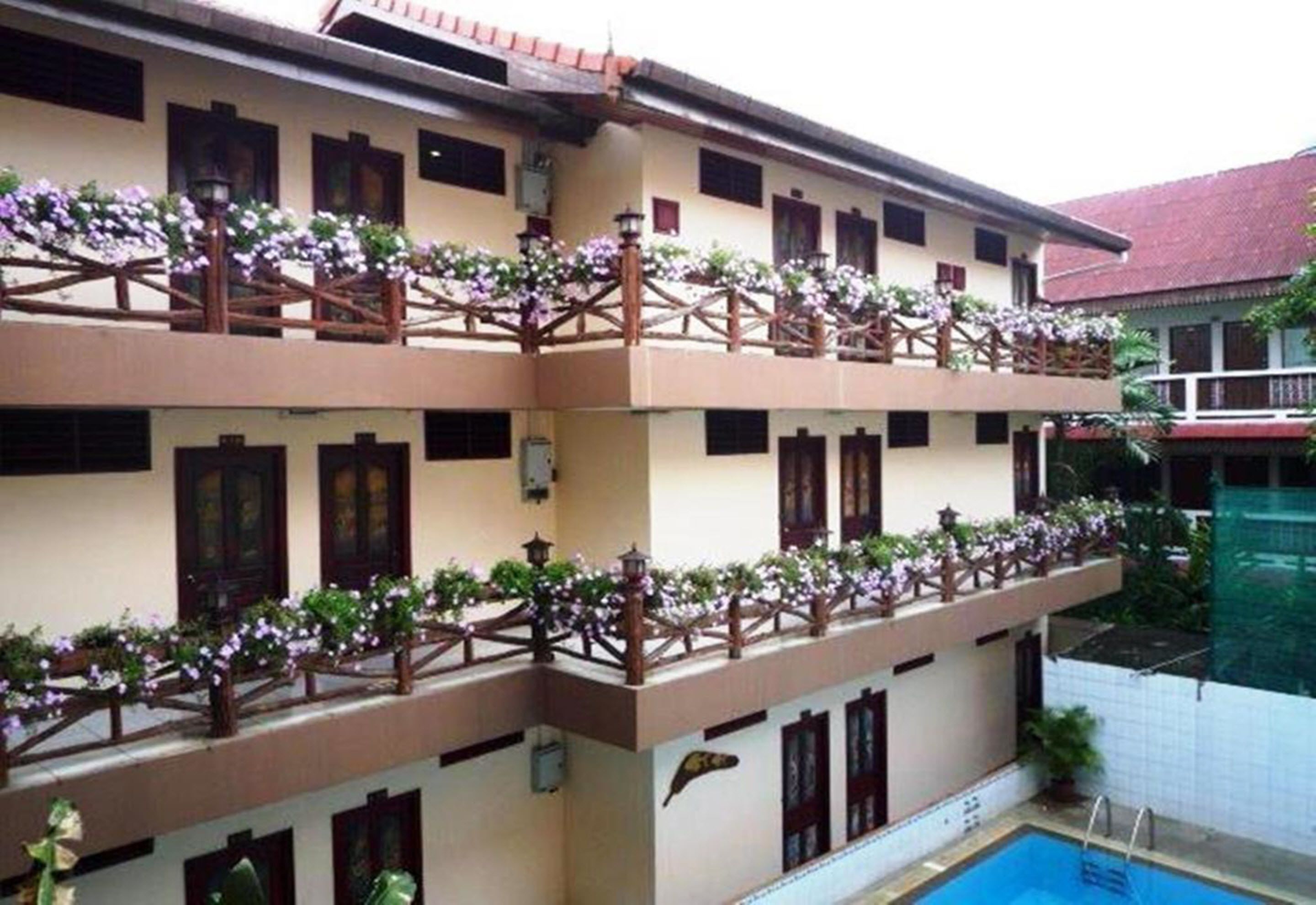 Un edificio de varios pisos con balcones decorados con plantas florecientes.