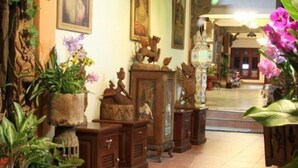 Una habitación con un cartel que indica sala de internet, muebles de madera y diversos objetos decorativos.