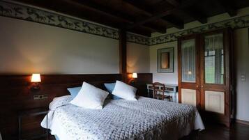 Une chambre à coucher avec un grand lit, une tête de lit en bois, deux lampes de chevet et un bureau en bois avec une chaise.