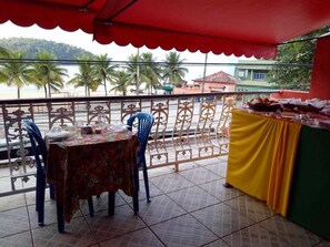 Un balcon avec une table dressée pour le repas, une chaise et une nappe.
