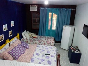 Une chambre avec deux lits, un réfrigérateur et une télévision.