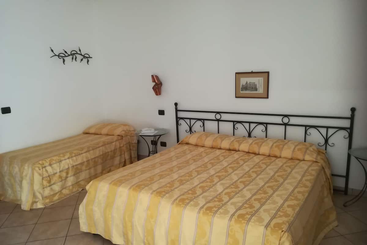 Een kamer met twee bedden, een klein tafeltje en een aan de muur hangend schilderij.