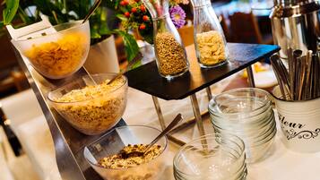 A breakfast buffet with various food items and utensils.