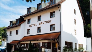 Un edificio de dos pisos con un letrero que dice "HOTEL GASTHOF".