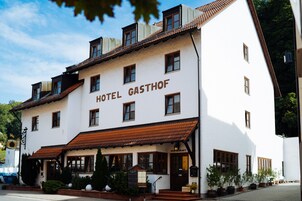 Um edifício de dois andares com uma placa que diz 'HOTEL GASTHOF'.